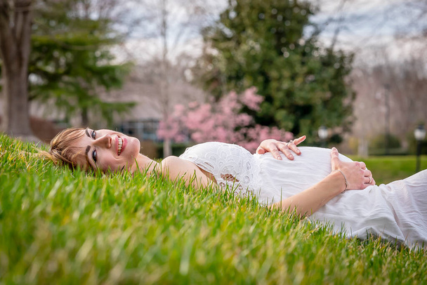 Egy gyönyörű várandós anya pózol a szabadban - Fotó, kép
