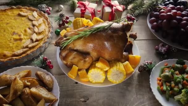 Thanksgiving Dag. Een pompoen. Happy Thanksgiving achtergrond houten tafel, versierd met kip, taart. Spar takken, geschenken. Zicht van bovenaf. 4K - Video