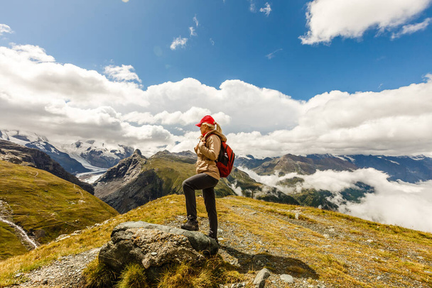 Zadní pohled na ženu s batohem při pohledu na pohled Žena turistka relaxační na vrcholu hory. - Fotografie, Obrázek