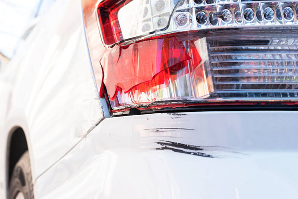 Brocken κόκκινο πίσω φανάρι χωρίς γυαλί και μεγάλη μαύρη γρατσουνιά στον πίσω προφυλακτήρα λόγω αυτοκινητιστικού ατυχήματος ή απρόσεκτη οδήγηση, ασφαλιστική περίπτωση, ασφάλεια οδήγησης έννοια - Φωτογραφία, εικόνα