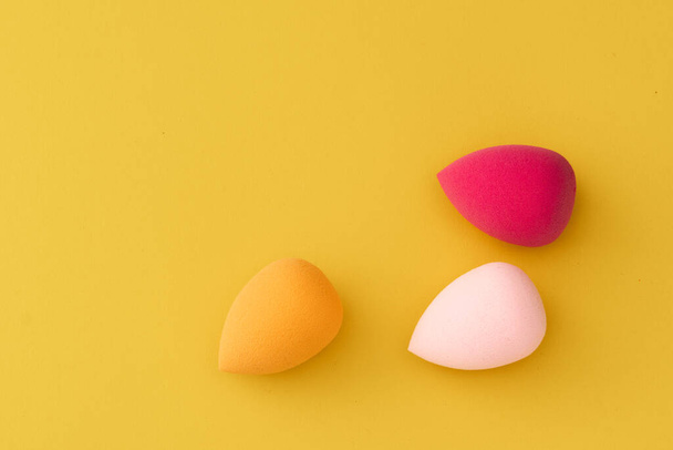 Makeup sponges round shape on a gentle yellow background - 写真・画像