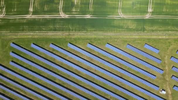 Temiz ekolojik elektrik enerjisi üretmek için birçok sıra güneş fotovoltaik paneli bulunan sürdürülebilir büyük elektrik santralinin havadan görünüşü. Sıfır emisyon kavramı ile yenilenebilir elektrik. - Video, Çekim