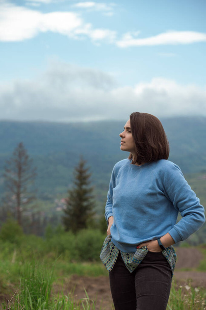 Young brunette woman looking at view at Carpathian mountains in Ukraine - Zdjęcie, obraz