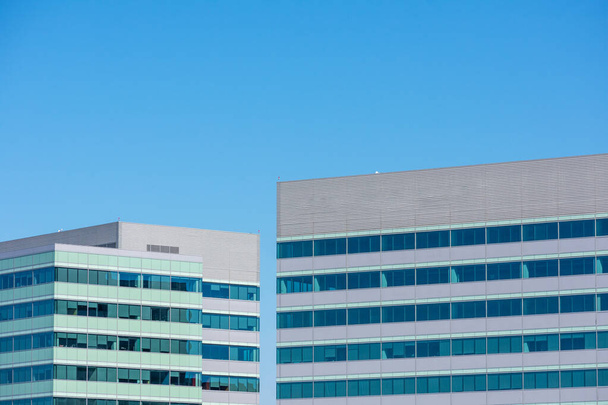 Ulkopuolella näkymä ylemmissä kerroksissa kaksi modernia toimistorakennus tornit. Sininen taivas. - Valokuva, kuva