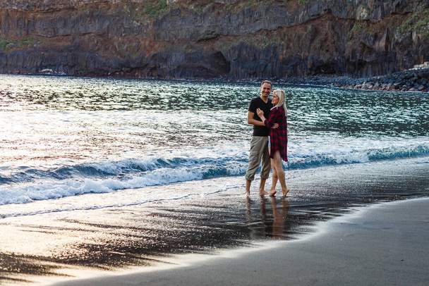 Casal de férias andando na praia juntos no amor segurando ao redor uns dos outros. Feliz casal jovem interracial, mulher asiática e homem caucasiano. - Foto, Imagem