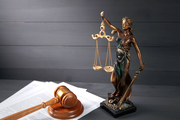 Statue der Gerechtigkeit, Papier und Hammer auf einem Holztisch. Hofkonzept - Foto, Bild