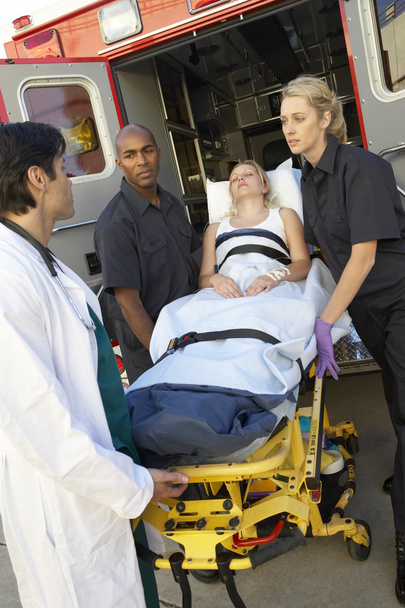 Paramedics and doctor unloading patient from ambulance - Photo, image