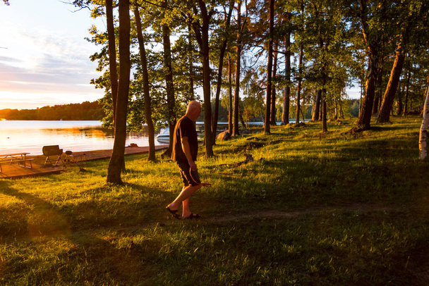Stockholm, Švédsko Muž kráčí v zapadajícím slunci na ostrově u jezera Malaren. - Fotografie, Obrázek