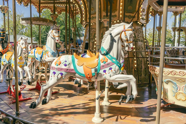 Kolotoč v pařížském stylu s koňmi v popředí. Zábavný koncept pro děti - Fotografie, Obrázek
