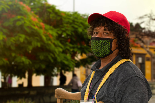 Straßenhändler mit Maske. Lockiges Haar Mann. Person auf Krücken. - Foto, Bild