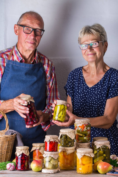 Couple âgé tenant dans les mains de la nourriture conservée - Photo, image