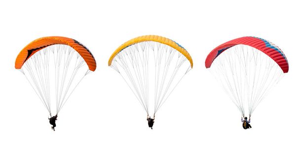 Beyaz arka planda izole edilmiş parlak renkli paraşüt, paraglider üzerinde uçan sporcu. Ekstrem spor anlayışı, macera mücadelesi. - Fotoğraf, Görsel
