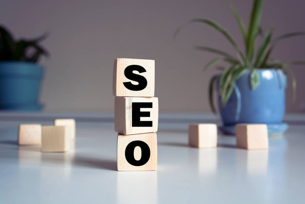 SEO concept. Wooden cubes and flower in a pot. - Photo, Image