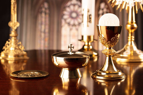 Première Communion. Thème religion catholique. Crucifix, la croix et le calice d'or et plaquette sur l'autel dans l'église. - Photo, image