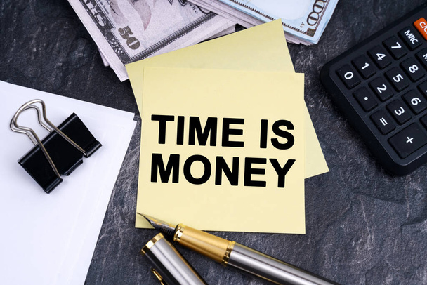 Фінанси та бізнес-концепція. На столі калькулятор, ручка, гроші та наклейки з написом - TIME IS MONEY
 - Фото, зображення