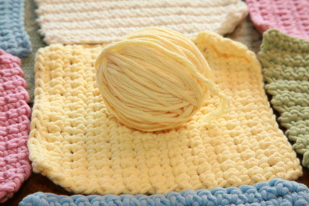 Crocheting. Crocheting with cotton threads. Crochet process with cotton yarn. Crochet patterns on a table. Crochet needlework close-up. Crochet knit thick yarn hobby. Yarns of different colors with crochet hook. Knitting, crochet supplies. yarn. - Photo, Image