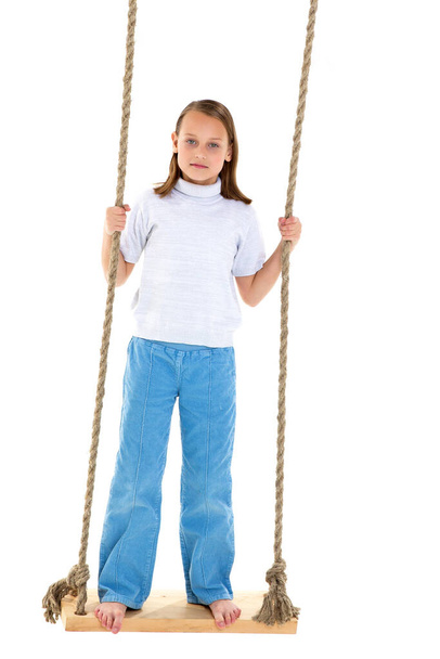 Preteen girl having fun on rope swing - 写真・画像