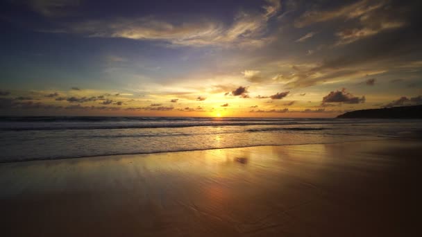 Dramatyczny zachód lub wschód słońca Płonące fioletowe niebo i błyszczące białe fale rozbijające się na piaszczystym brzegu Piękne odbicie światła na powierzchni morza Niesamowity krajobraz lub tło krajobrazu morskiego - Materiał filmowy, wideo