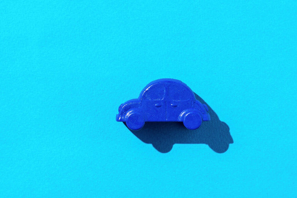 A small car model on a blue background. The concept of selling and buying cars. - 写真・画像
