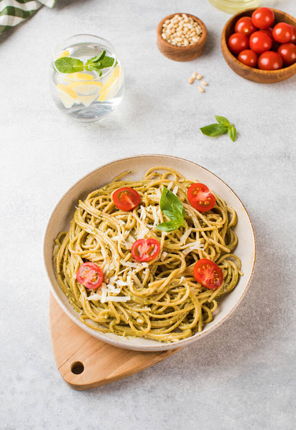 Spaghetti pasta with pesto sauce and cherry tomatoes on a plate. Menu, Italian cuisine. - Zdjęcie, obraz