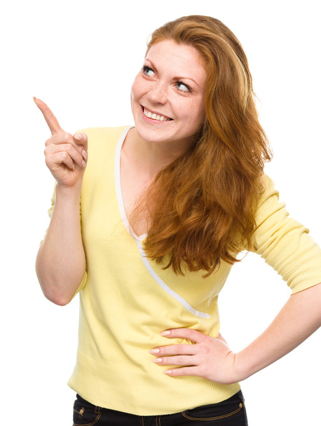 Portrait of a young woman pointing to the left - Foto, Imagen