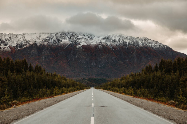 A wet asphalt road on the background of foggy mountains - Foto, Imagen