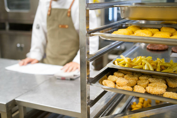 A closeup shot of fast food on trays in a kitchen - Fotó, kép