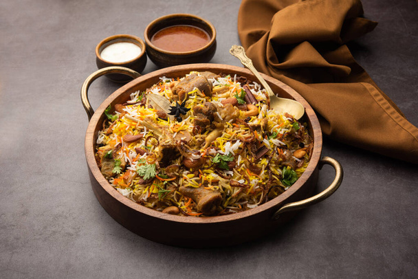 Indian Mutton biryani prepared in Basmati Rice served with Yogurt dip over moody background, Selective focus - Φωτογραφία, εικόνα