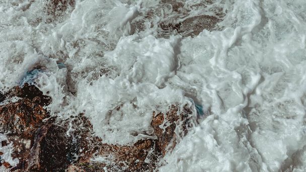 Imagen de formaciones rocosas (piedras), con textura y nitidez, en la playa durante el día - Foto, Imagen