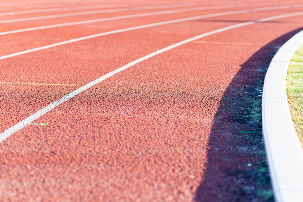 Part Red plastic track in the outdoor track and field stadium.Closeup. - Foto, afbeelding