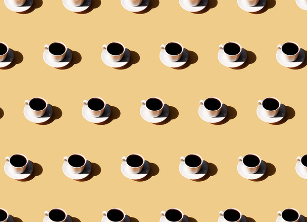 Patroon van koffiekop en plaat, schaduw van de zon op beige terracotta achtergrond - Foto, afbeelding