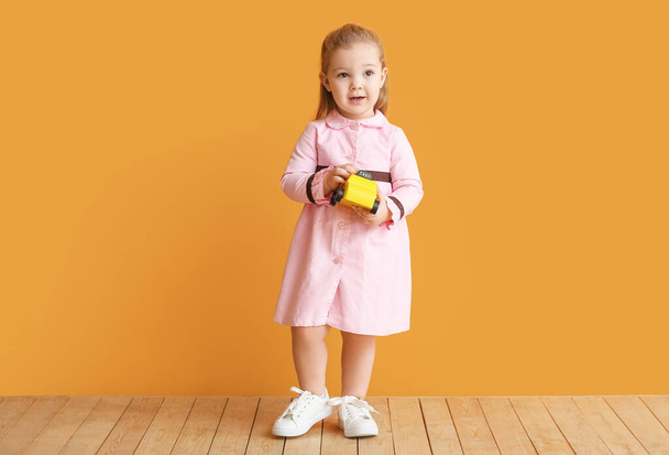Милая маленькая девочка рядом с цветной стеной - Фото, изображение