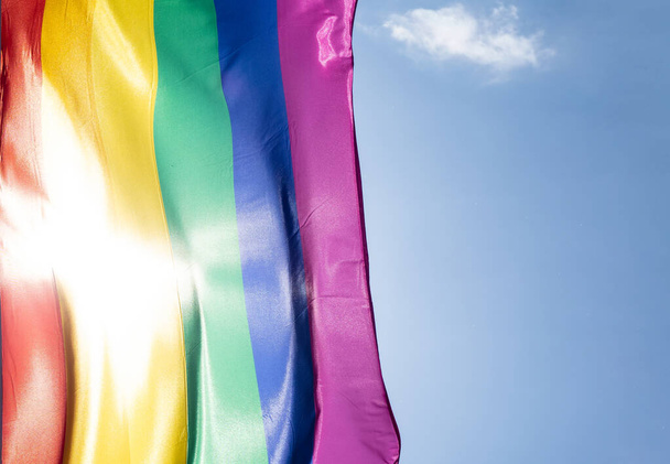 Rainbow flag in sunshine against blue sky - Foto, Bild