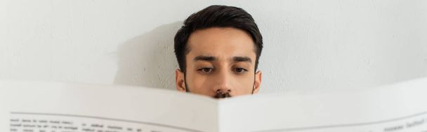 Молодий чоловік читає розмиту газету вдома, банер
  - Фото, зображення