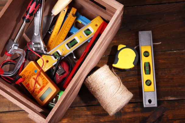Wooden box with different tools, on rustic wooden background - Photo, Image