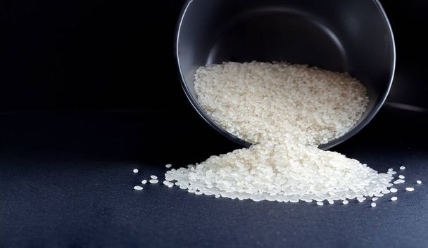arroz blanco redondo en un tazón sobre un fondo oscuro - Foto, Imagen