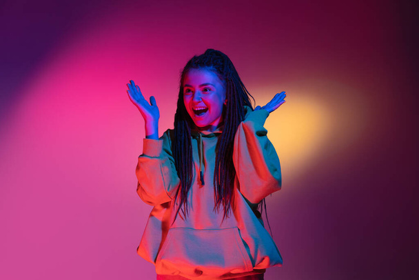Young womans portrait on gradient colors studio background in neon. Concept of human emotions. - Foto, immagini
