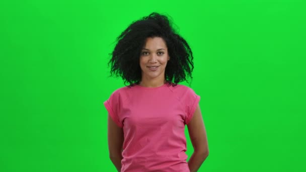 Portrait of young female African American nods her head and points not to do it with a gesture. Black woman with curly hair poses on green screen in the studio. Close up. Slow motion ready 59.97fps. - Video