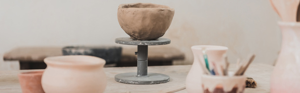 скульптурная глиняная чаша на деревянном столе в мастерской керамики, баннер - Фото, изображение