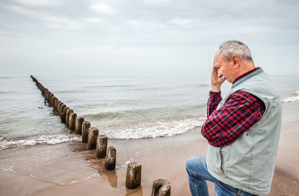 Pensativo homem idoso de pé na praia
 - Foto, Imagem