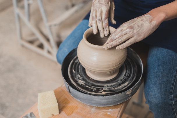 high angle view of young african american woman working with wet clay pot in pottery - Photo, Image