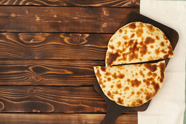 Baked homemade flatbread on wooden background close up - Foto, imagen
