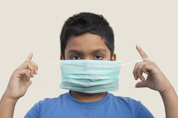 Chłopiec stosujący medyczną maskę ochronną do ochrony zdrowia przed wirusem Corona - Zdjęcie, obraz