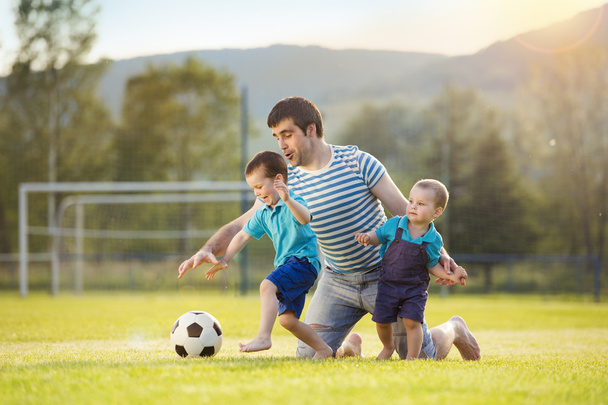 Father with sons playing football - Foto, Imagen