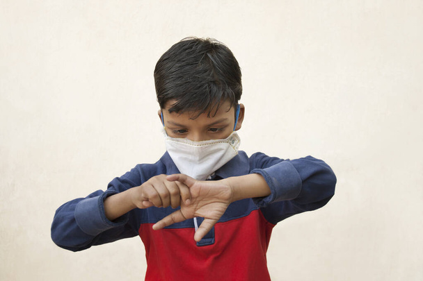 Chlapec v masce obličeje si myje ruce dezinfekčním prostředkem. - Fotografie, Obrázek
