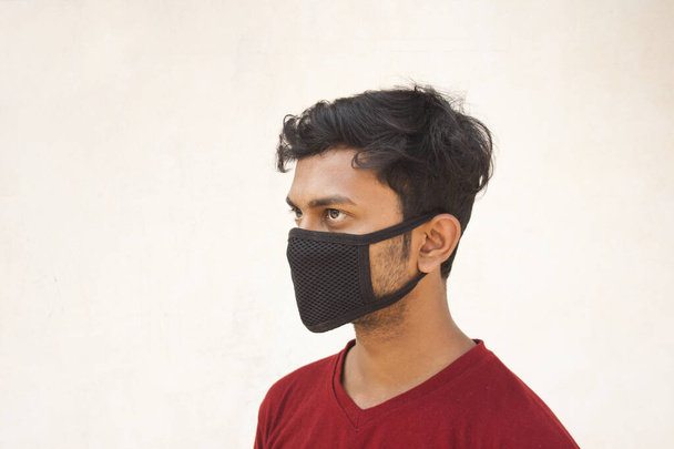 Indische Junge bedeckt ihr Gesicht mit Verschmutzungsmaske zum Schutz vor Viren - Foto, Bild