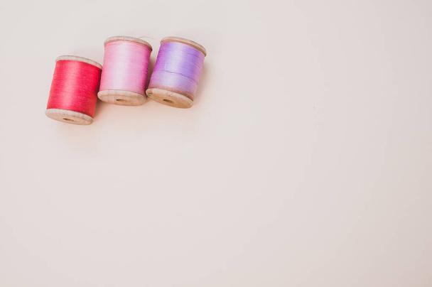 A colorful sewing threads on a light background with free space for text - Foto, Imagem