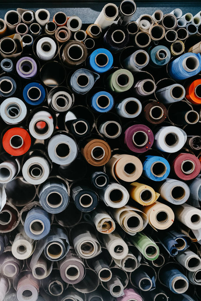 A closeup of rolls of colorful textile and fabric for roller blinds in a factory. - Valokuva, kuva