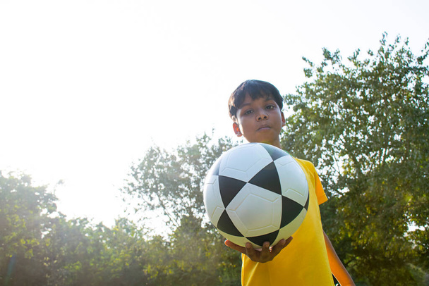 Joven sosteniendo pelota de fútbol - Foto, imagen