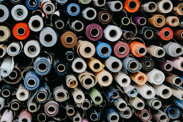 Een close-up van rollen kleurrijke textiel en stof voor rolgordijnen in een fabriek - Foto, afbeelding